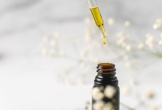 dropping CBD oil in a bottle