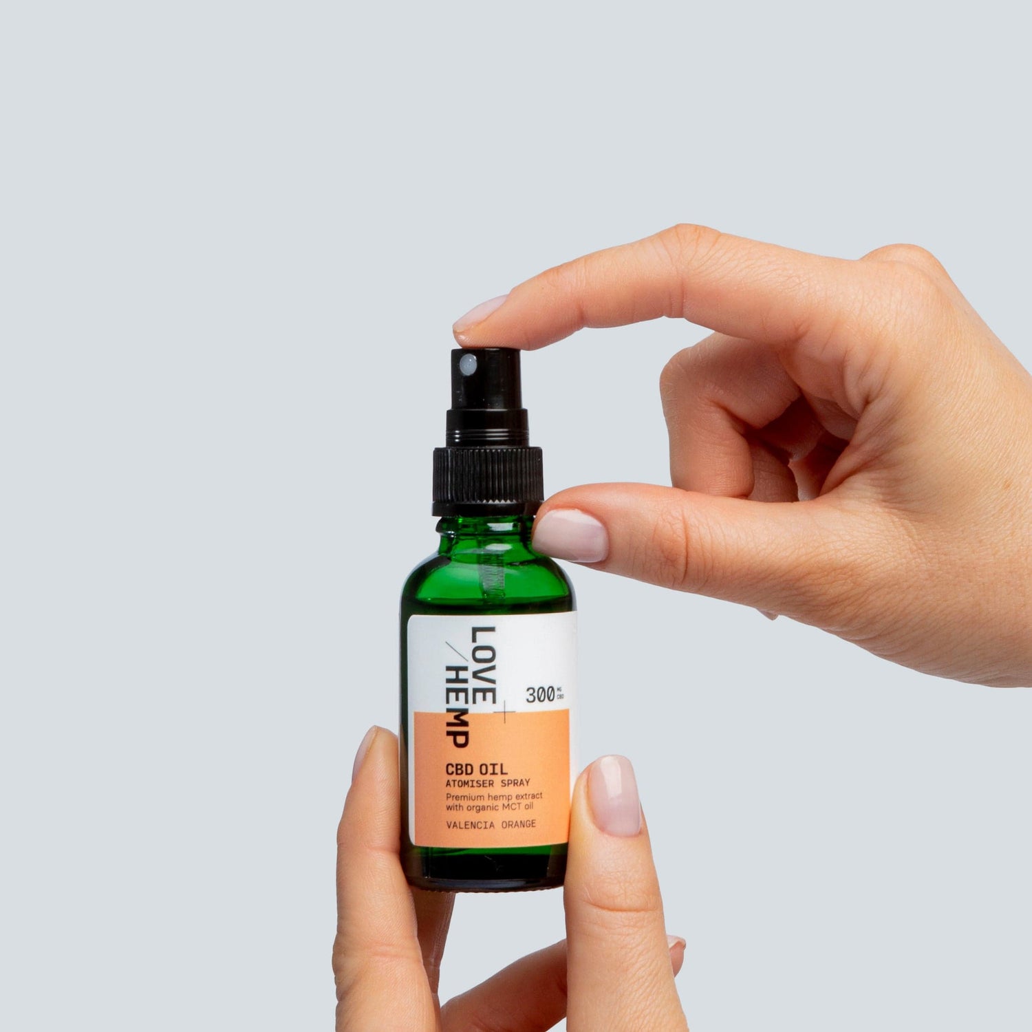 hand holding CBD Oil Spray 300mg valencia orange