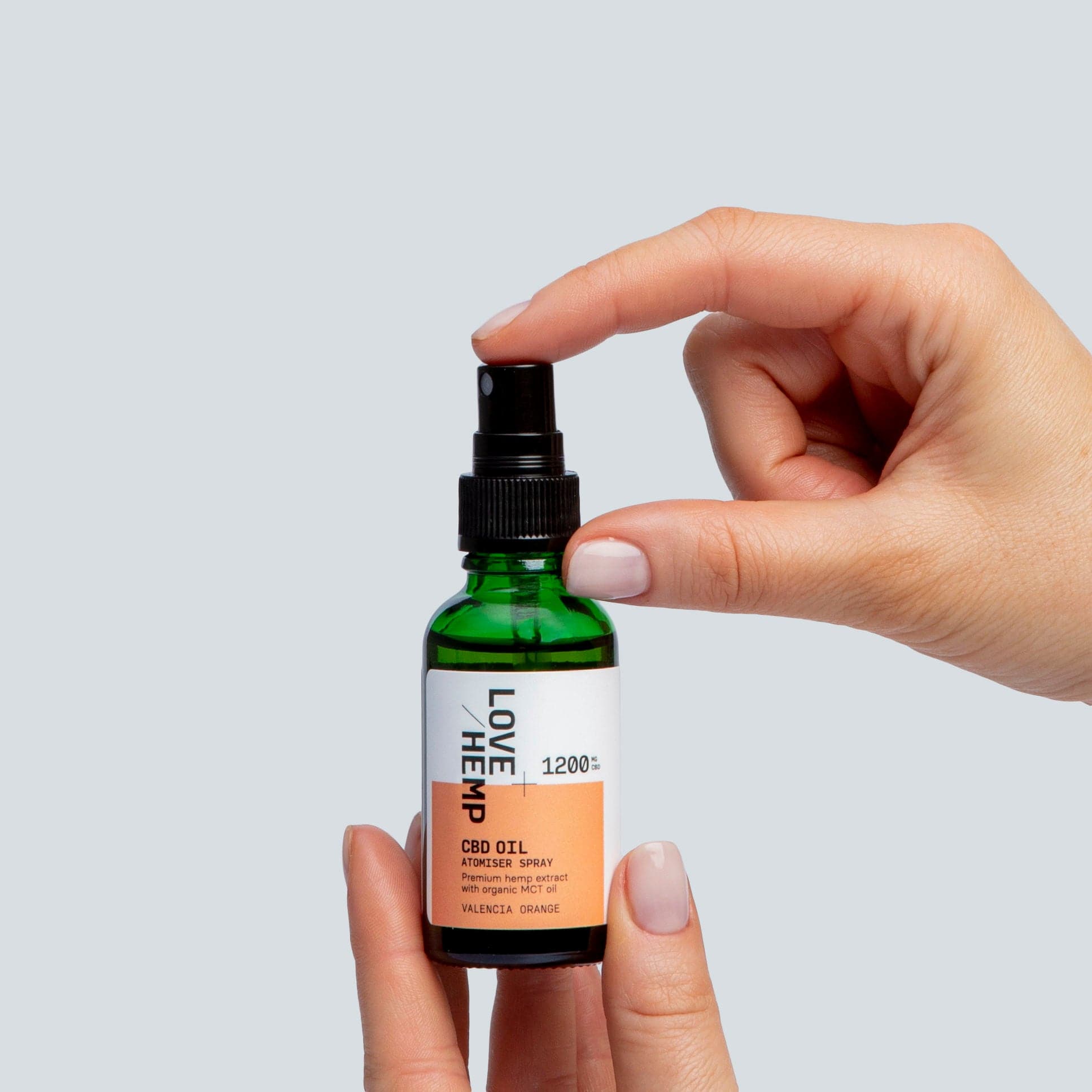 hand holding CBD Oil Spray 1200mg valencia orange